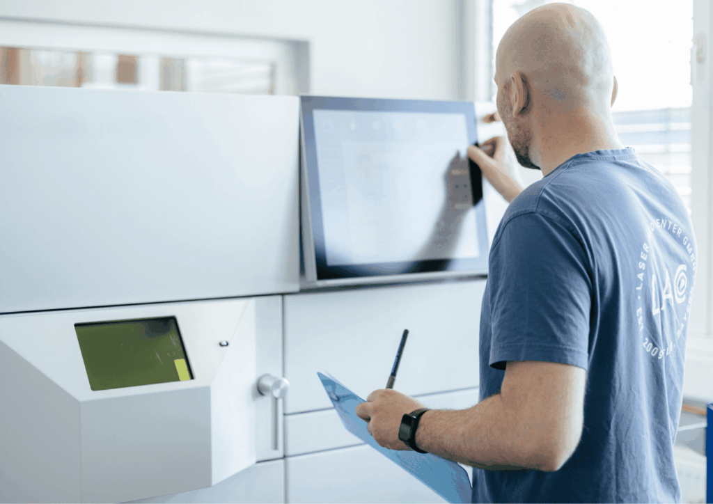 Ein Mitarbeitender von Laser Add Concept führt an der Laserschmelzmaschine eine Qualitätsprüfung für den 3D Druck mit Metall durch